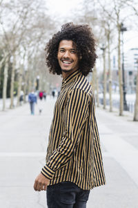 Portrait of smiling young woman standing in city