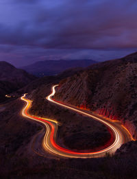 Aerial view of illuminated mountain road against sky at night