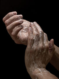 Close-up of hand holding finger against black background