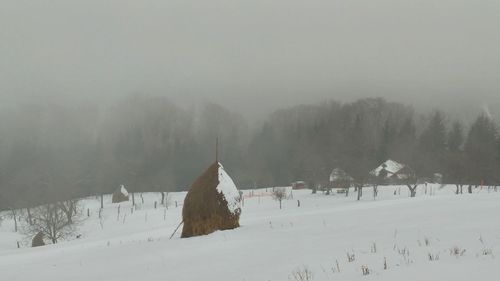 Snow covered landscape against sky