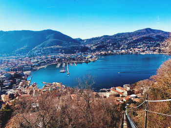 High angle view of city by sea against blue sky