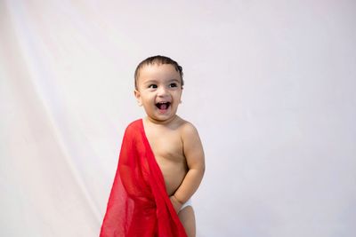 Portrait of smiling boy standing against white background