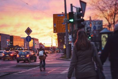 Rear view of people on street during sunset in city