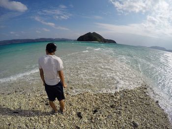 Rear view of woman standing on beach