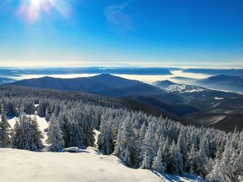 Scenic view of snowcapped mountains against blue sky