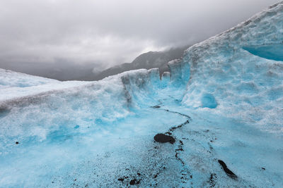 High angle view of frozen lake against cloudy sky