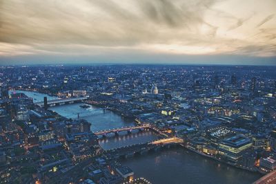 Aerial view of cityscape against cloudy sky