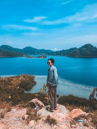 Full length of man standing on rocks against sky