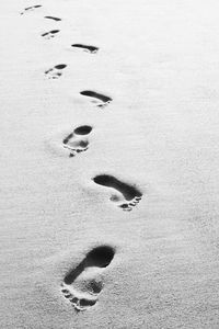 High angle view of footprints on sand at beach during winter