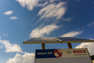 Low angle view of information sign against sky