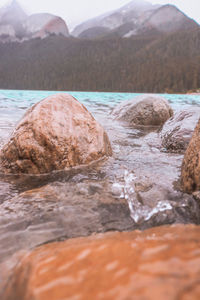 Surface level of rocks in sea against mountains