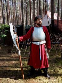 Adult man dressed in historical costume with poleaxe