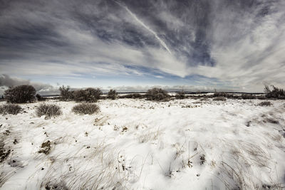 Scenic view of snow covered land against sky