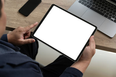 Midsection of man using digital tablet