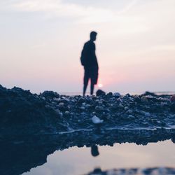 Silhouette man standing against sky during sunset