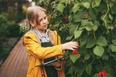 A little girl is exploring nature by writing down her research on a tablet. curious children