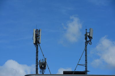 Low angle view of communications tower against blue sky