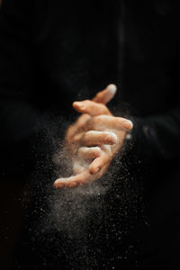 Close-up of person hand against black background