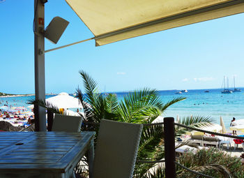 Swimming pool by sea against clear blue sky