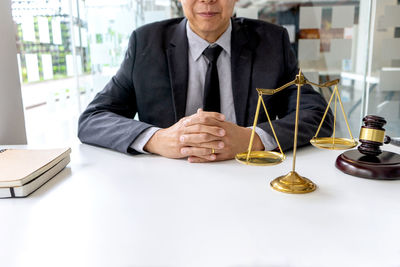 Midsection of man sitting on table