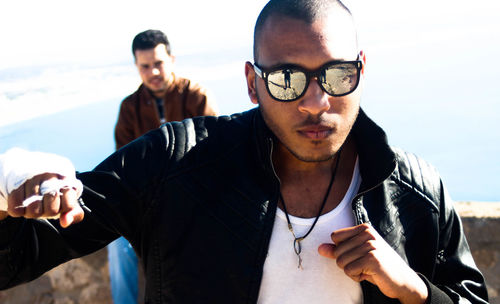 Portrait of young man with sunglasses against sky