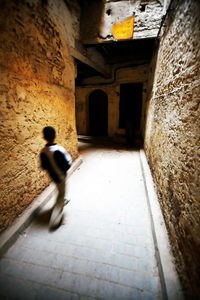 Man walking in corridor of building