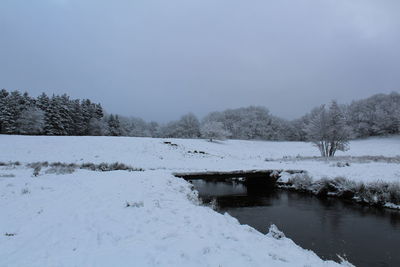 Frozen lake against clear sky during winter