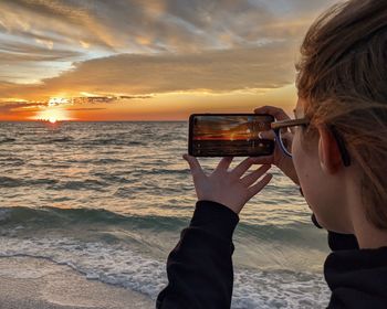 Teenager girl photographing at beach