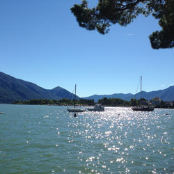 Boats in sea against clear sky