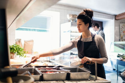 Full length of woman standing in kitchen