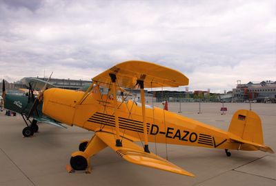 Airplane on airport runway against sky