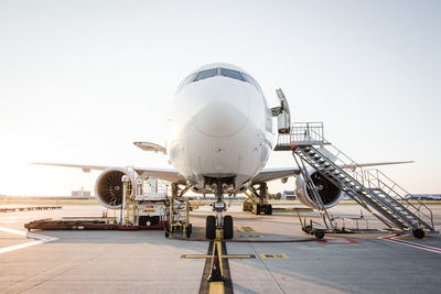 Airplane at runway against sky