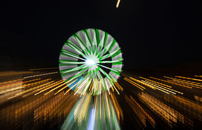 Low angle view of illuminated ferris wheel against sky at night