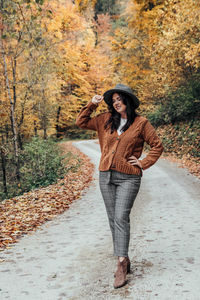 Front view of young woman on road in autumn, fall. outdoors, lifestyle, fashion.