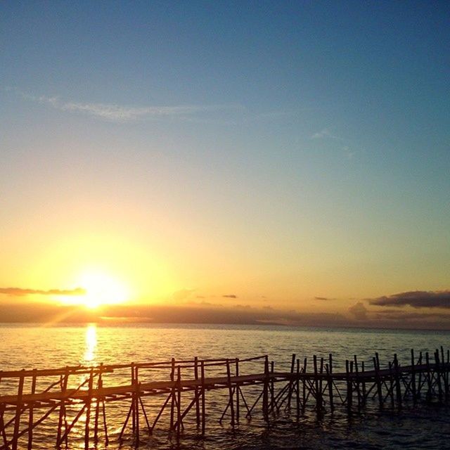 sea, sunset, water, horizon over water, sun, scenics, tranquil scene, tranquility, beauty in nature, sky, nature, orange color, railing, idyllic, sunlight, pier, beach, outdoors, silhouette, sunbeam