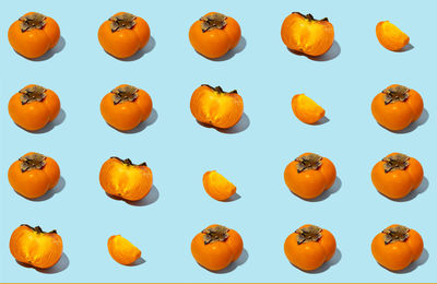 Persimmon fruit with leaves on blue background. healthy eating and food concept. flat lay, top view