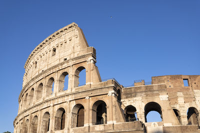 Low angle view of historical building against clear blue sky