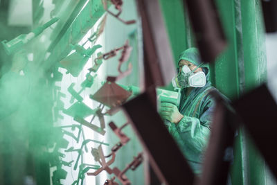 Painters spraying steel components in spray booth of a factory