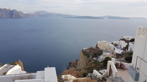 High angle view of townscape by sea against sky