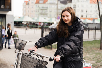 Woman sitting on bicycle at street in city