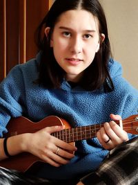 Portrait of young woman holding guitar