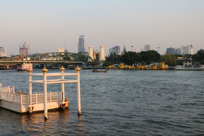 Scenic view of river by city against clear sky