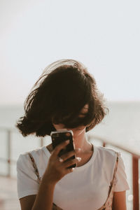 Portrait of woman photographing with mobile phone