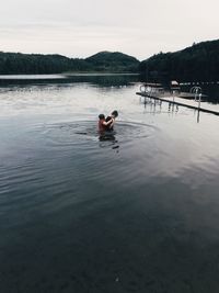 People in lake against sky