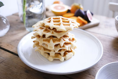 Close-up of waffles in plate on wooden table