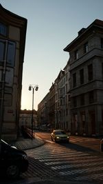 Cars parked on city street against clear sky