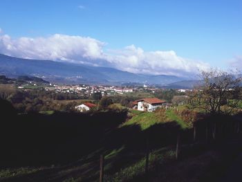 Town by mountains against blue sky