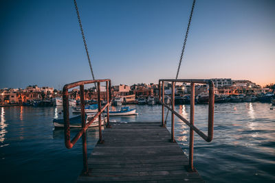 Pier over sea against clear sky during sunset