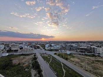 High angle view of road by buildings against sky during sunset