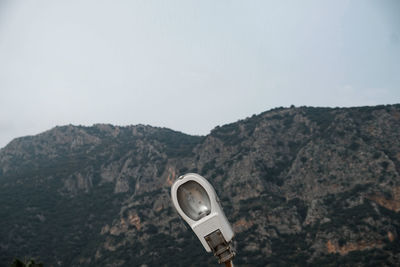 Telephone booth against mountain range against sky